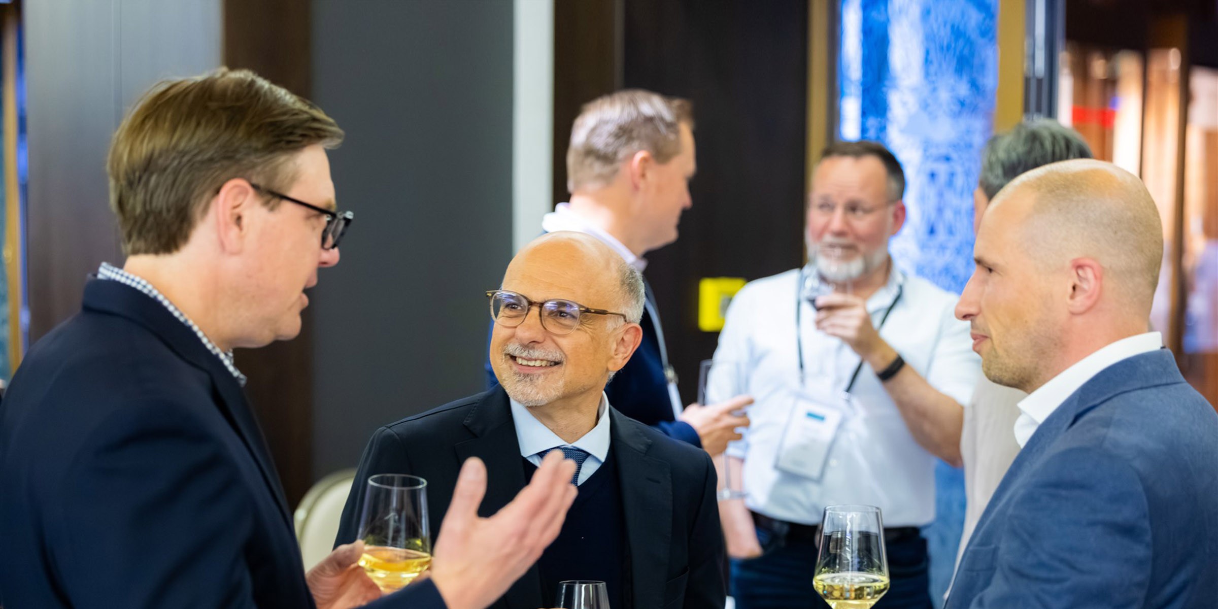 Three smiling businessmen socialising at conference