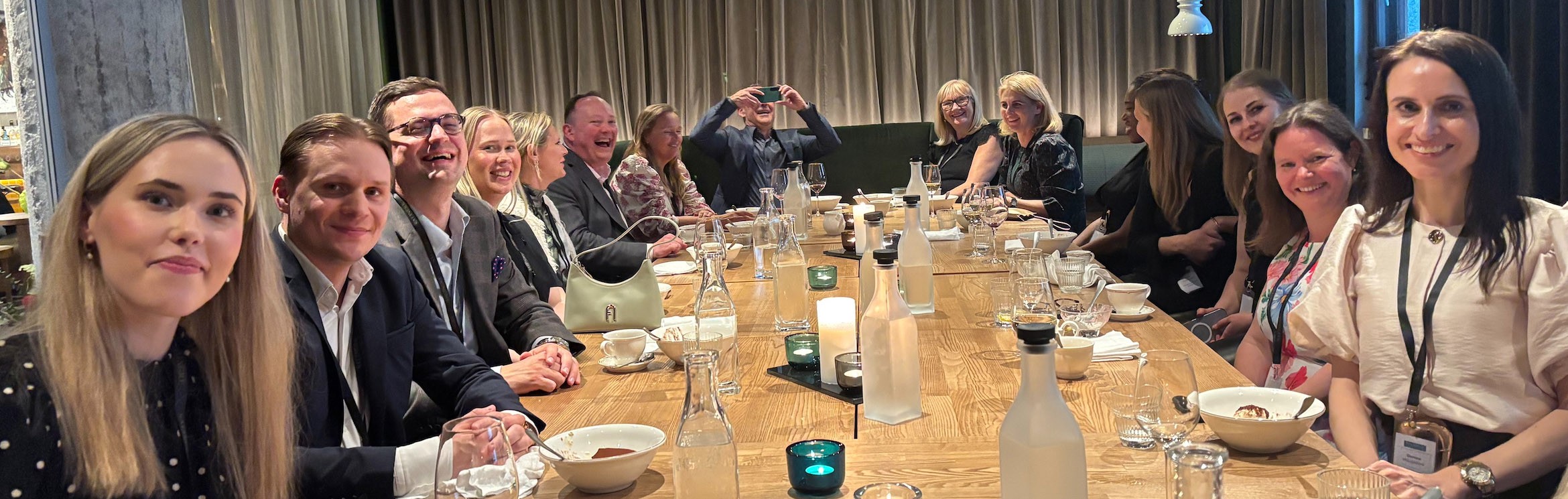 In image of smiling business women around a large dining table